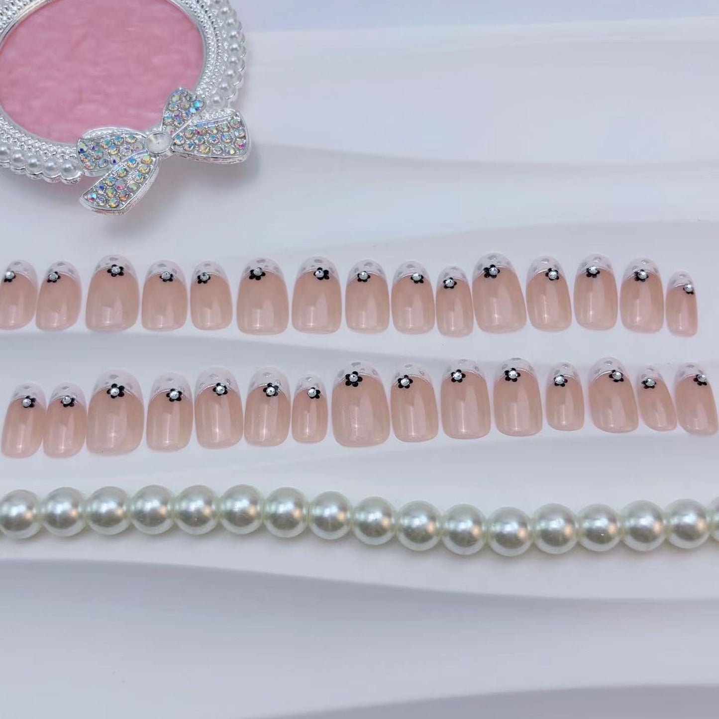 24Pcs French Tip Press On Nails Short Almond Fake Nails Nude Pink with Black Flowers & Silver Rhinestones Glossy Acrylic False Nails with Glitter Edge,Full Cover Stick On Nails for Women DIY Manicure
