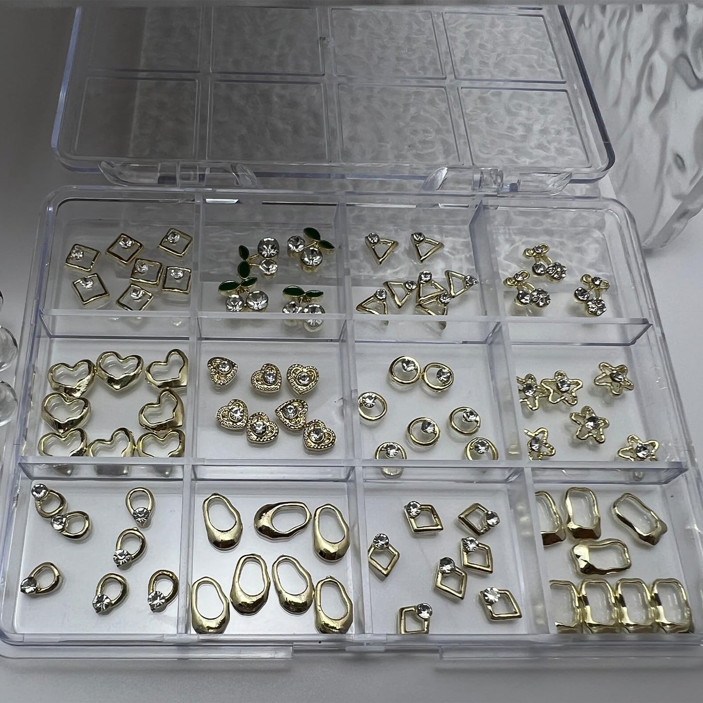 Pizadix 96PCS Gold Nail Charms Kit, 12 Styles 3D Alloy Rhinestones (Hearts/Stars/Leaves & Geometric), 12-Grid Organizer Box & Tweezer, for Gel, Acrylic & Press-On Nails